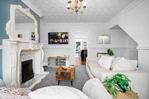 ein Wohnzimmer mit einer weißen Couch und einem Kamin in der Unterkunft Luxurious 3 Bedroom House with Parking 73B - Top Rated - Netflix - Wifi - Smart TV in Holly Lane