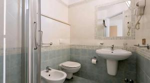 a bathroom with a sink and a toilet and a mirror at Hotel Baltic in Misano Adriatico +30 photos