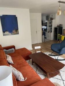 uma sala de estar com um sofá e uma mesa em Maison proche ville olympique et stade de France em Saint-Denis