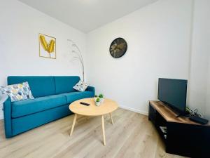 un soggiorno con divano blu e tavolo di Charmant T2 * proche plage * parking gratuit a La Rochelle