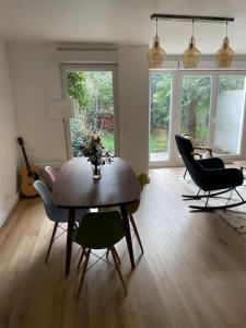 uma sala de estar com uma mesa de jantar e cadeiras em Maison proche ville olympique et stade de France em Saint-Denis