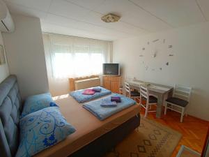 a bedroom with a bed and a dining room at Studio Ema in Niš