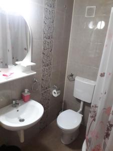 a bathroom with a white toilet and a sink at Studio Ema in Niš