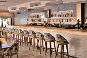 a row of bar stools in a restaurant at Hotel Mamora Kénitra in Kenitra