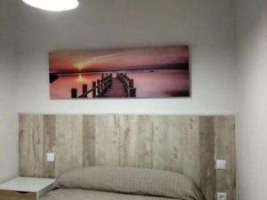 a bedroom with a picture of a pier on the wall at Apartamento Nuncio Viejo by Toledo AP in Toledo