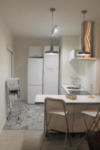 una cocina con electrodomésticos blancos, mesa y sillas en Apartamento Nuncio Viejo by Toledo AP en Toledo