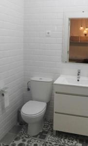 a white bathroom with a toilet and a sink at Apartamento Nuncio Viejo by Toledo AP in Toledo