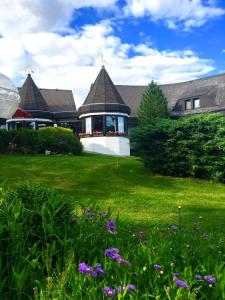 a house with a green yard with purple flowers at Landhotel Hubertus in Unterelsbach