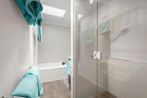 a shower with a glass door in a bathroom at Hobart City Townhouse in Hobart
