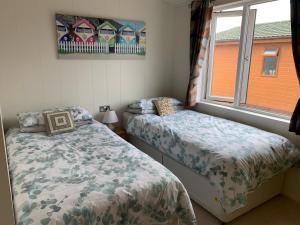 a bedroom with two beds and a window at 23 Ocean View Lodge TJS 23875 in Ilfracombe