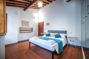 a bedroom with a large white bed with blue sheets at Roommo Oltrarno in Florence