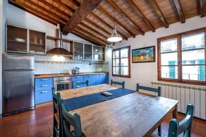 a kitchen with a wooden table and blue cabinets at Roommo Oltrarno in Florence