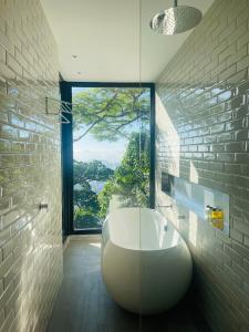 uma casa de banho com uma banheira branca e uma grande janela. em Pousada Rio144 no Rio de Janeiro
