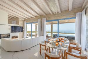 a living room with a table and chairs and a couch at My Kefalonia Villa in Minia