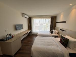 a hotel room with two beds and a television at PRESIDENCY AIRPORT HOTEL in Cochin