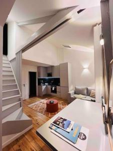 a living room with a staircase and a piano at Joli duplex, coeur du Pouliguen in Le Pouliguen