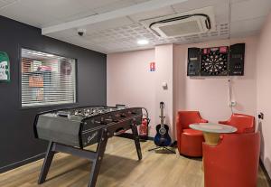 una habitación con una mesa y un tablero de dardos en la pared en B&B HOTEL Rouen Centre Rive Gauche, en Rouen