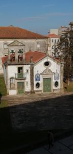 un vieux bâtiment avec un homme qui marche devant lui dans l'établissement Alex Point - Guest House, à Viana do Castelo