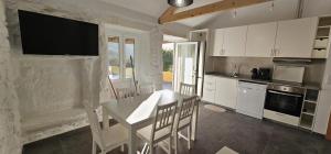a kitchen with a table and a television on the wall at Casa Lima - AL in Valença