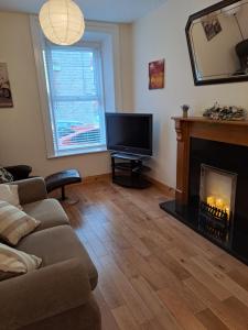 a living room with a couch and a fireplace at Drogheda Townhouse in Drogheda