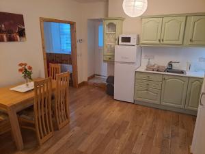 cocina con mesa y nevera blanca en Drogheda Townhouse, en Drogheda