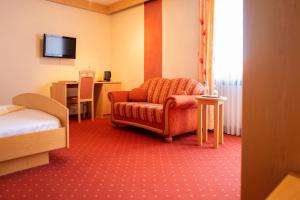 a hotel room with a chair and a table at Königsteiner Hof in Königstein in der Oberpfalz