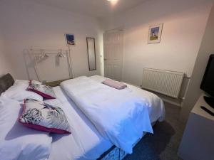 濱海聖安妮斯的住宿－New Flat in Lytham St Annes - Sleeps 4，卧室内的两张床,配有白色床单和枕头