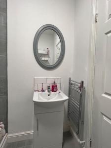 a white bathroom with a sink and a mirror at New Flat in Lytham St Annes - Sleeps 4 in Saint Annes on the Sea