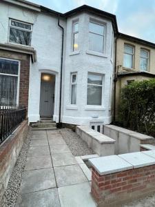 a white house with a front door and a sidewalk at New Flat in Lytham St Annes - Sleeps 4 in Saint Annes on the Sea