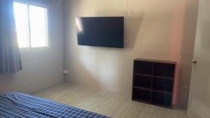 ein Schlafzimmer mit einem Bett und einem TV an der Wand in der Unterkunft KARON STUDIO APARTMENT in Ka Rorn