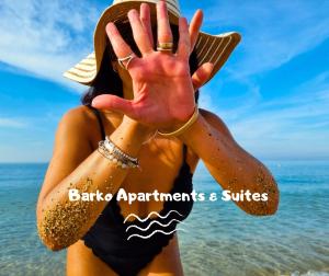 Una mujer parada en la playa con las manos en alto en Barko Apartments & Suites, en Steccato