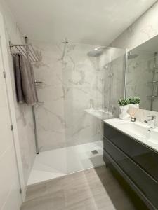 y baño con ducha, lavabo y espejo. en Super2beachfront, en Marbella
