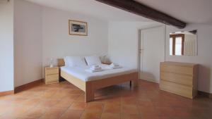 een slaapkamer met een wit bed en een houten vloer bij Italianway - Piazza Nuova 3 in San Fedele Intelvi