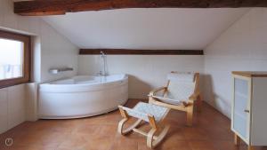 een badkamer met een bad en een stoel. bij Italianway - Piazza Nuova 3 in San Fedele Intelvi
