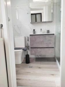 a bathroom with a toilet and a sink and a mirror at D&G City Centre Home in Heraklio