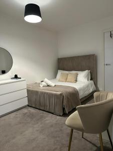a bedroom with a bed and a dresser and a chair at Beautiful 1-Bed Apartment in Birmingham - Solihull in Birmingham