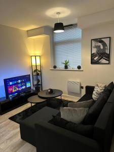a living room with a couch and a table and a tv at Beautiful 1-Bed Apartment in Birmingham - Solihull in Birmingham