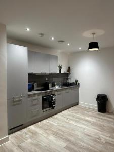 a kitchen with stainless steel appliances and white cabinets at Beautiful 1-Bed Apartment in Birmingham - Solihull in Birmingham