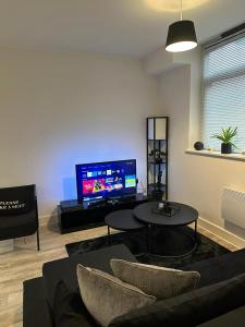 a living room with a couch and a tv at Beautiful 1-Bed Apartment in Birmingham - Solihull in Birmingham