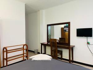 a room with a mirror and a desk and a mirror at Ritz Gate Kalutara in Kalutara