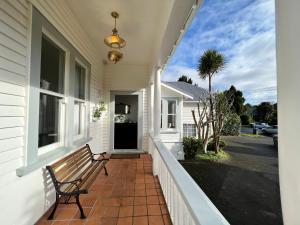 a bench on the front porch of a house at La Casa Bonita Auckland in Auckland