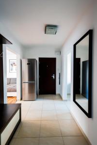 a living room with a refrigerator and a mirror at Coldweek apartment - Samorin near X-bionic sphere in Šamorín