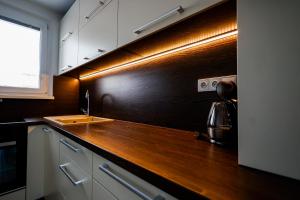 a kitchen with a wooden counter top and a sink at Coldweek apartment - Samorin near X-bionic sphere in Šamorín