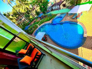 una vista aérea de una piscina con 2 sillas en Shivam Resort With Swimming Pool ,Managed By The Four Season - 1 km from Calangute Beach en Goa