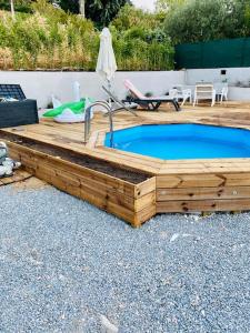 a wooden deck with a swimming pool and a sink at Villa charme et tradition in Poulx