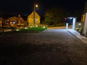 a brick driveway with a building in the background at night at Lot in Zagreb