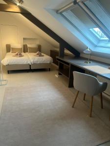 a attic room with a bed and a desk and a chair at Velo Villa in Achel +21 photos