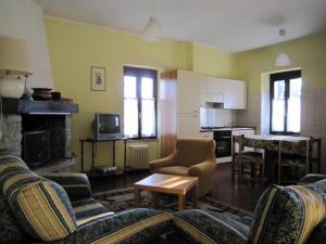 a living room with two couches and a kitchen at Peaceful Farmhouse in Verbania with Garden in Verbania