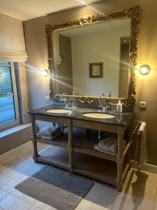 a bathroom with two sinks and a large mirror at Velo Villa in Achel
