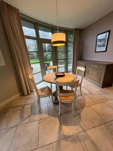 a dining room with a wooden table and chairs at Velo Villa in Achel